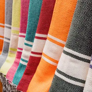 Colorful patterned textiles hanging in a row.