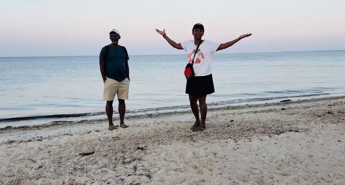 Two people enjoying a calm beach at sunset.